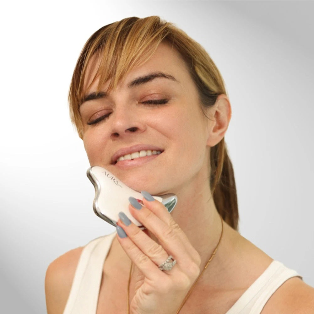 Woman using Aura Vibe Gua Sha Massager on her face